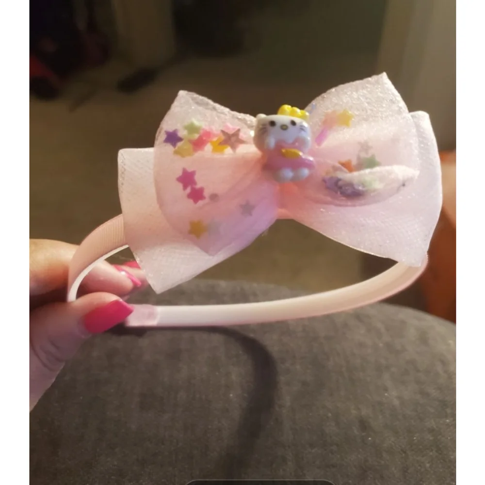 Four Hello Kitty headbands with small figurine